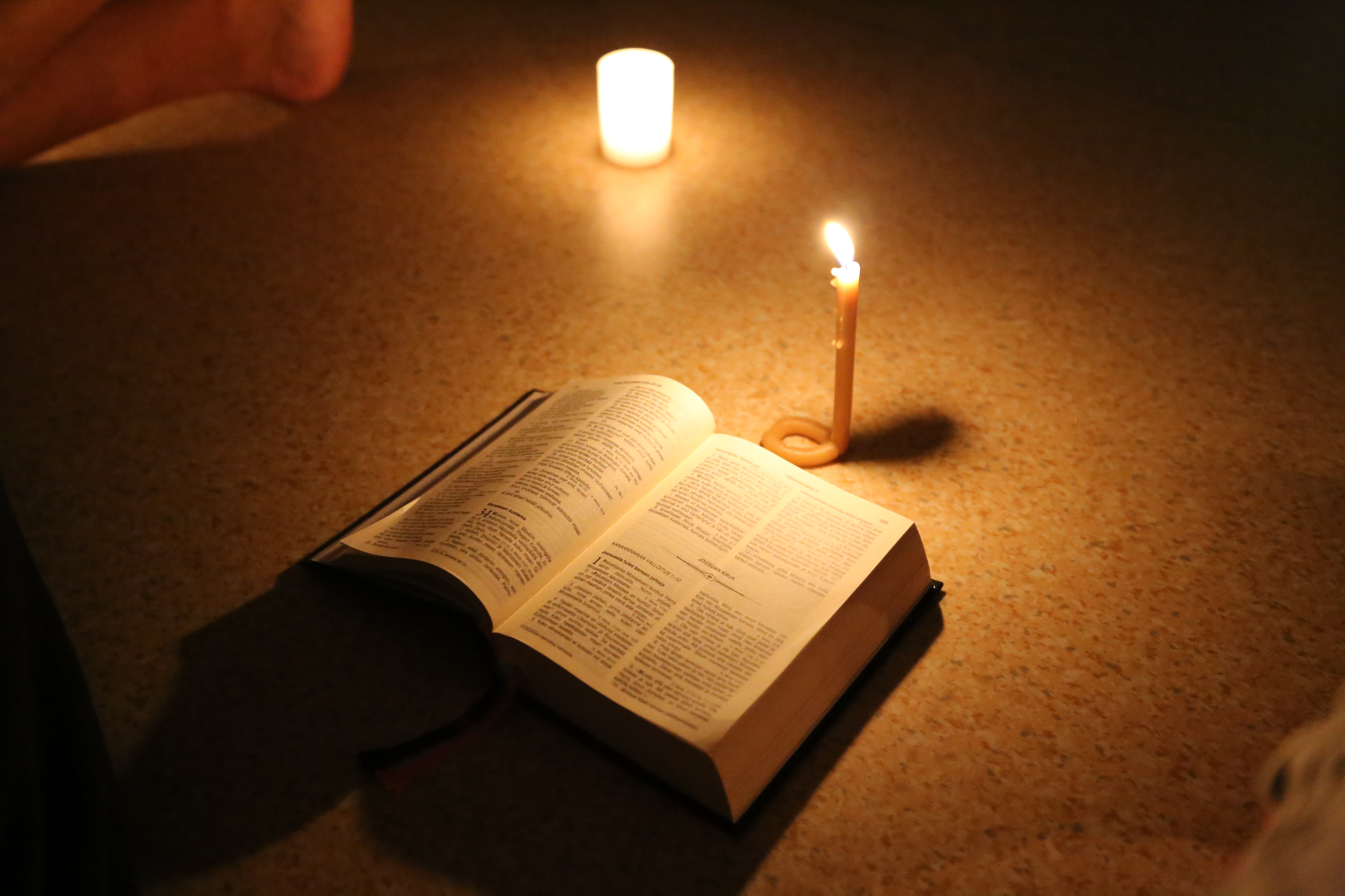 kynttilä, raamattu ja rukoushelmet