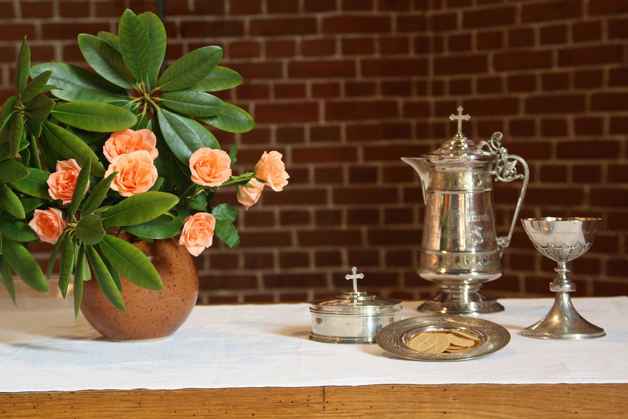 ehtoollistarvikkeet pöydällä ja kukkia maljakossa